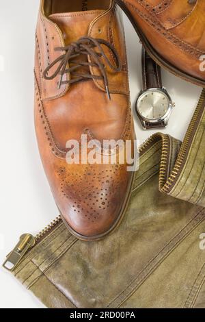 Uhren, Jacken und Schuhe aus echtem Leder. Ein klassisches Lederzubehör für Herrenbekleidung. Vertikal Stockfoto