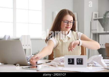 Junge Geschäftsfrau, die unter der Frist im Amt arbeitet Stockfoto