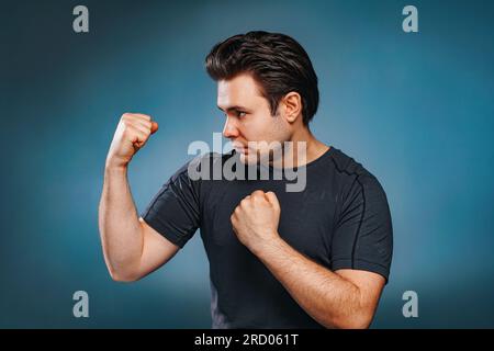 Junger brünetter Kämpfer auf blauem Hintergrund Stockfoto