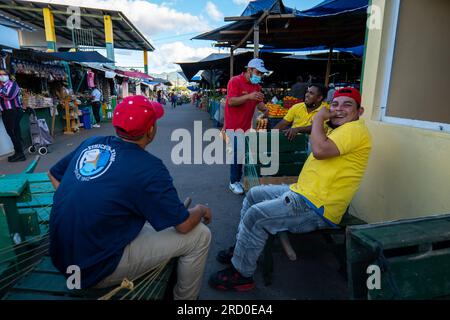 Tegucigalpa, Francisco Morazan, Honduras - 16. Dezember 2022: Workers Sitting on Wood Boxes Smile im farbenfrohen Markt „Mercado mayoreo“ in der Nähe der Nation Stockfoto