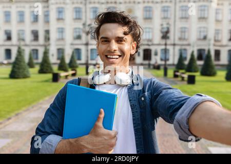 Gutaussehender Student Guy Nimmt Selfie Im Freien Gegen Das Universitätsgebäude Mit Stockfoto