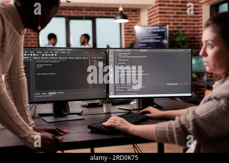 Verschiedene Programmieringenieure, die HTML-Code und Cloud-Computing in der IT-Entwicklungsagentur entwickeln. Softwareentwickler, der an der Datenbankprogrammierung mit HTML-Skript arbeitet und Big Data berechnet. Stockfoto