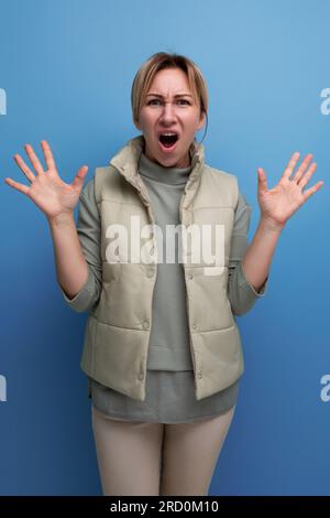 Schockierte 30-jährige blonde Frau in lässiger Kleidung mit Emotionen im Gesicht Stockfoto