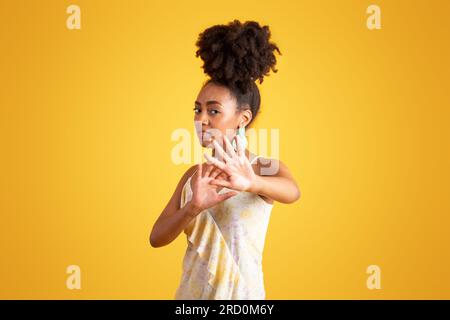 Verängstigte, traurige, verwirrte junge schwarze Frau weigert sich, ein Foto zu machen, und macht mit den Händen ein Stoppschild Stockfoto