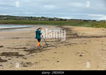 Dunnet Bay, Caithness, Schottland, Juli 4. 2023, ein Metalldetektor durchkämmt den Sand am Strand und sucht nach verlorenen Metallgegenständen. Stockfoto