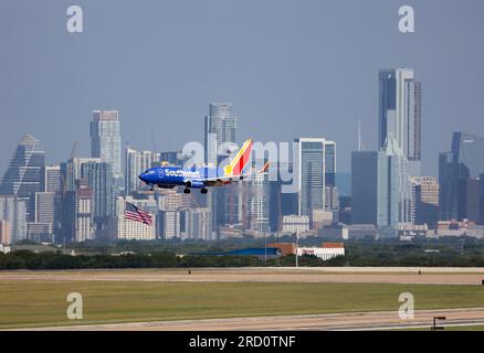 13. Juli 2023: Ein Flug von Southwest Airlines landet am 13. Juli 2023 am Austin Bergstrom International Airport außerhalb von Austin, Texas. Die Skyline der Innenstadt von Austin ist in der Ferne zu sehen. (Kreditbild: © Scott Coleman/ZUMA Press Wire) NUR REDAKTIONELLE VERWENDUNG! Nicht für den kommerziellen GEBRAUCH! Stockfoto