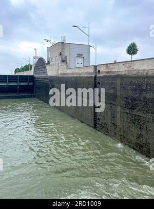 Wien, AT – 10. Juni 2023 Vertikale Ansicht der beeindruckenden Schleuse Freudenau und des Kraftwerks. Ein Durchflusskraftwerk an der Donau in Osterreich Stockfoto