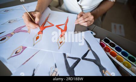 Eine gesichtslose Frau zeichnet Aquarelle von Sportbekleidung. Nahaufnahme der Hände eines Modedesigners. Stockfoto