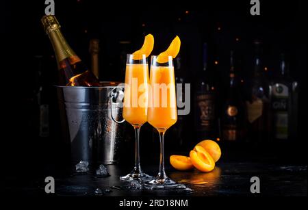 Apricot Bellini alkoholisches Cocktailgetränk mit Prosecco, Cava oder Sekt mit Aprikosenpüree, Sirup und Eis, dunkler Bartheke Hintergrund, Kopien Stockfoto