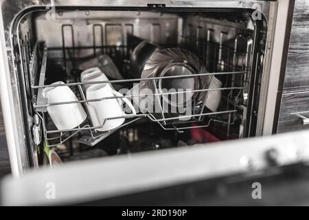 Reinigen Sie das Geschirr bei geöffneter Tür im Geschirrspüler Stockfoto