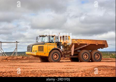 Ein gelber Muldenkipper steht auf dem Sand Stockfoto