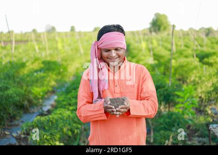 Glücklicher indischer Bauer, Bauer, der Boden in den Händen hält Stockfoto