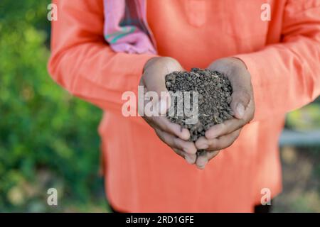 Glücklicher indischer Bauer, Bauer, der Boden in den Händen hält Stockfoto