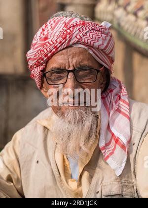 Hala, Sindh, Pakistan - 11 16 2019 : Nahaufnahme eines alten bärtigen Mannes mit Brille und rot-weißem Turban im späten Nachmittagslicht Stockfoto