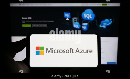 Person, die ein Mobiltelefon mit dem Logo der Cloud-Computing-Plattform Microsoft Azure auf dem Bildschirm vor der Unternehmenswebseite hält. Konzentrieren Sie sich auf das Display des Telefons. Stockfoto