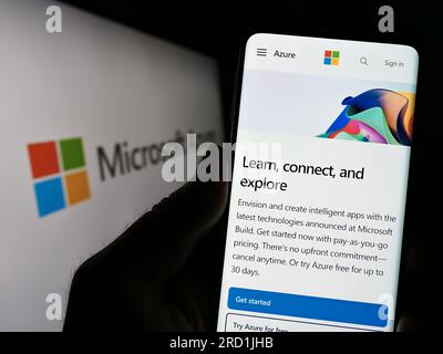 Person, die ein Smartphone mit einer Website der Cloud-Computing-Plattform Microsoft Azure auf dem Bildschirm vor dem Logo hält. Konzentrieren Sie sich auf die Mitte des Telefondisplays. Stockfoto