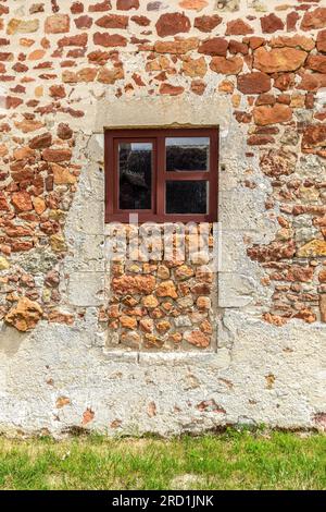 Blockierte Türöffnung mit traditionellen Baumaterialien aus rotem Stein, die für Häuser in der Brenne verwendet werden - Rosnay, Brenne, Indre (36), Frankreich. Stockfoto