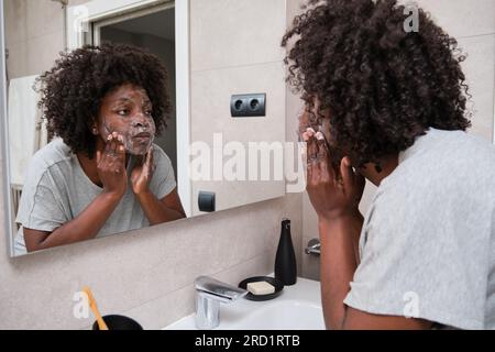 Eine afrikanische Frau erhält ihre Schönheit durch tägliche Gesichtswäsche mit Seife. Stockfoto