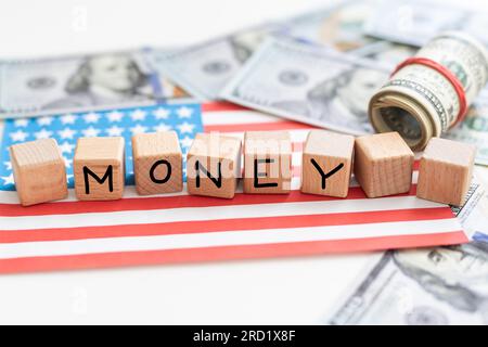 Geld in der Politik. Das Wort Geld in Briefblöcken geschrieben, mit dem Wort Politik in einem Kreis. Hintergrund der amerikanischen Flagge. Stockfoto