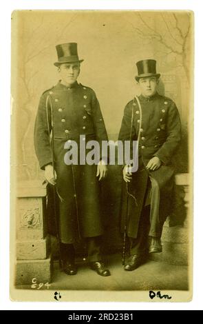 Originale Studiopostkarte aus den frühen 1900er Jahren mit 2 walisischen Kutschern in Uniform, mit Pferdepeitschen, aus dem Studio von Sargent, 249 Holton Rd, Barry, Vale of Glamorgan, Wales, Anfang der 20er Jahre. Stockfoto