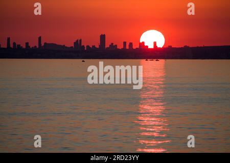 Silhouette der Wolkenkratzer der Stadt Benidorm bei Sonnenuntergang von Calpe, Spanien aus gesehen Stockfoto