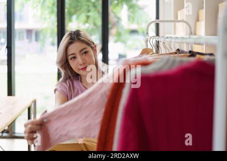Asiatische Modedesignerin skizziert das Design eines neuen Kleides in einem Modestudio Stockfoto