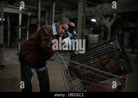 Porträt einer unglücklichen jungen Immigrantin oder Bettler, die Bier trinkt Stockfoto