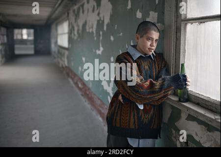 Obdachlose betrunkene junge Frau mit schwelender Zigarette im Mund Stockfoto