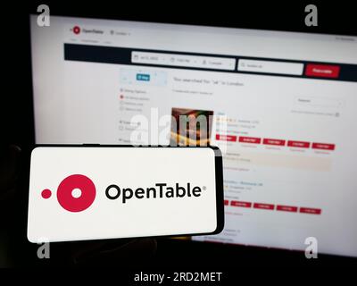 Person, die ein Smartphone mit dem Logo des US-amerikanischen Reservierungsdienstleisters OpenTable Inc. Auf dem Bildschirm vor der Website hält. Konzentrieren Sie sich auf das Display des Telefons. Stockfoto