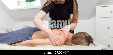 Frauen, die eine Schultermassage in einem hellen Schönheitssalon erhalten. Thai-Massagetherapie. Entspanntes schwarzes Mädchen mit Ganzkörpermassage im neuen Spa, Seitenblick Stockfoto