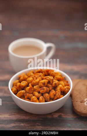 Nahaufnahme knuspriger indischer Snacks mit heißem Tee oder Kaffee und handgemachten Plätzchen (Kekse). Studioaufnahmen in abgesenktem Winkel. Stockfoto