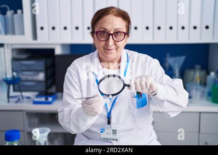 Senior-Wissenschaftlerin mit Lupenhaltspillen im Labor Stockfoto