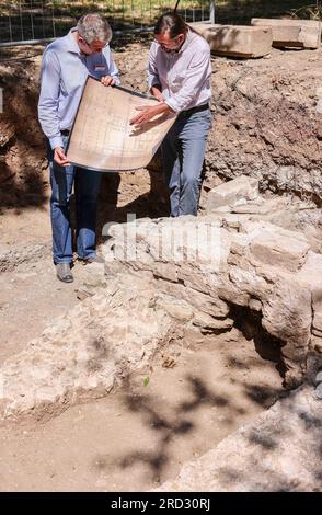 18. Juli 2023, Sachsen-Anhalt, Zeitz: Holger Rode (r), Excavation Manager, und Donat Wehner, Project Manager, halten während der Ausgrabungsarbeiten auf dem Gelände des ehemaligen Posa-Klosters einen historischen Plan. Archäologen haben hier umfassende Details der ehemaligen Gebäude entdeckt. So sind beispielsweise einige Wände im Südflügel des Gehäuses unerwartet gut erhalten, und die Nordfassade des Klosters ist in einer Höhe von etwa 70 Zentimetern über eine Länge von etwa zehn Metern noch erhalten. Das Benediktinerkloster Posa wurde 1114 erbaut. 1573 war es d Stockfoto