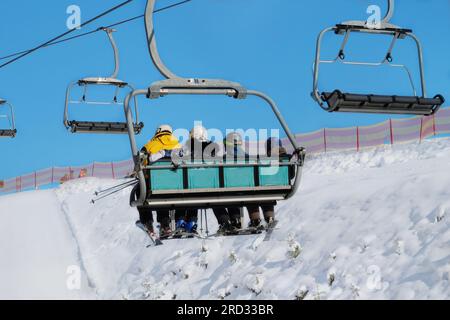 Skifahrer fahren im Skigebiet mit dem Aufzug den Berg hinauf. Skifahren im Winter. Urlaub in den Bergen im Skigebiet. Stockfoto