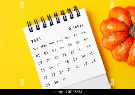 Oktober 2023 Kalender und Kürbisse auf gelbem Hintergrund. Stockfoto