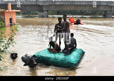 Neu-Delhi, Indien. 13. Juli 2023. Die Menschen wandern durch das Hochwasser, da mehrere Teile der Hauptstadt Delhi zu überschwemmen begannen, nachdem der Yamuna-Fluss am 13. Juli 2023 in der Nähe von Neu-Delhi, Indien, seine Evakuierungsmarkierung überschritten hatte. Indiens Hauptstadt Neu-Delhi begann mit der Evakuierung Hunderter Einwohner wegen der Gefahr einer Überschwemmung, da der Wasserstand des Yamuna-Flusses, der durch die Stadt fließt, in Rekordhöhe gestiegen ist. (Foto: Arnav Kaushik/Pacific Press/Sipa USA) Guthaben: SIPA USA/Alamy Live News Stockfoto