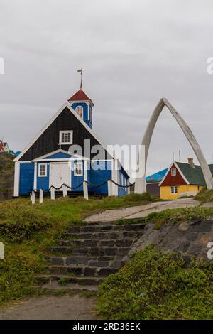 Bethal-Kirche Alte blaue Kirche 1775 mit Walknochenbogen und altes Haus B-32 im Sisimiut Museum in Sisimiut, Grönland an einem nassen Regentag im Juli Stockfoto