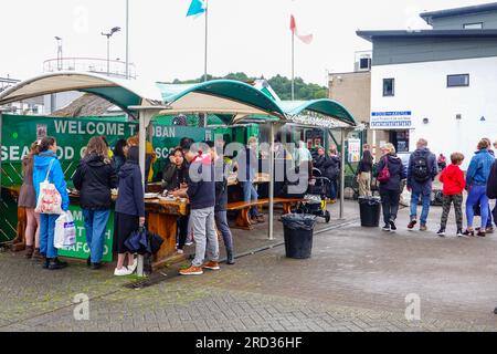 Leute stehen und essen lokale schottische Meeresfrüchte draußen, Oban Seafood Hut, Green Shack, am Hafen, Hafen, Oban Scotland, Großbritannien. Stockfoto