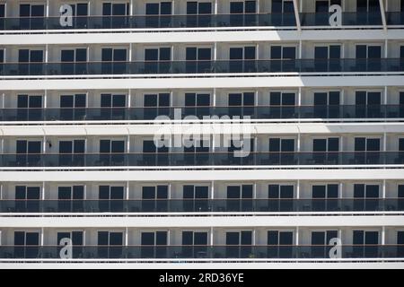Ein großes Kreuzfahrtschiff-Kabinenfenster zeigt eine Reihe von Kabinen-Balkonen Stockfoto