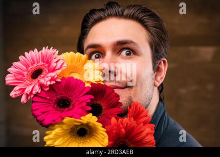 Junger, gutaussehender Mann mit Blumenporträt Stockfoto
