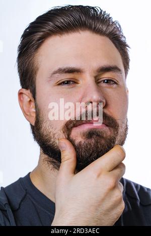Junger, nachdenklicher Mann mit Bartporträt auf weißem Hintergrund Stockfoto