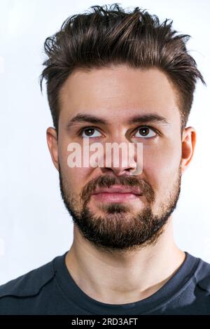 Junger unzufriedener Mann mit Bartporträt auf weißem Hintergrund Stockfoto