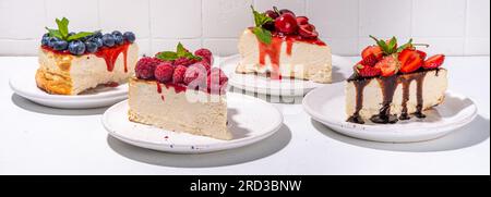 Hintergrund des Backmenüs im Sommer, süße Käsekuchen-Portionen mit verschiedenen Garnierungen, Marmelade und Beerenobst - Erdbeere, Heidelbeere, Himbeere, ch Stockfoto
