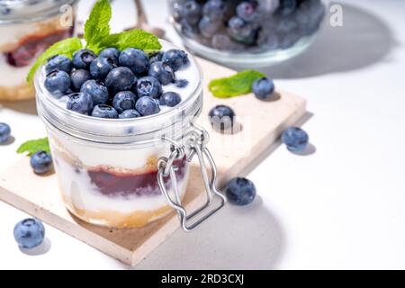 Mehrschichtiges Blaubeerparfait-Dessert, Käsekuchen im Glas mit Vanillekekuchen, cremiger Joghurt, Marmelade und frischer Blaubeere Stockfoto
