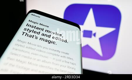 Smartphone mit Website der Videobearbeitungssoftware iMovie (Apple Inc.) auf dem Bildschirm vor dem Unternehmenslogo. Fokus auf oberer linker Seite des Telefondisplays. Stockfoto