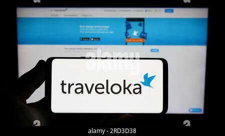 Person, die ein Smartphone mit dem Logo des indonesischen Reiseunternehmens Traveloka auf dem Bildschirm vor der Website hält. Konzentrieren Sie sich auf das Display des Telefons. Stockfoto