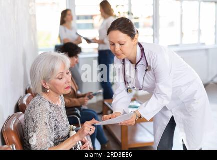 Ärztin, die der älteren Frau die Ergebnisse der ärztlichen Untersuchung vorlegt Stockfoto