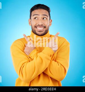 Lächeln, asiatischer Mann und Hand zeigen auf das Studio für Nachrichten, Angebote oder Rabatte oder Anleitungen auf blauem Hintergrund. Happy, Choice und männliche Show Timeline Stockfoto