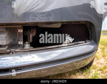 Nebelscheinwerfer aus einem Fahrzeug herausgenommen, um eine durchgebrannte Glühlampe zu ersetzen. Stockfoto