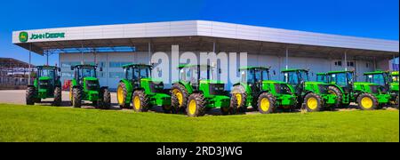 Kiew, Ukraine - 24. August 2020: Die leistungsstarken Traktoren im John Deer-Geschäft in Kiew, Ukraine, am 16. Juni 2020. Reihe brandneuer John Deere-Traktoren vor dem Laden des örtlichen Konsortiums, Ausstellung der neuesten landwirtschaftlichen Maschinen. Stockfoto